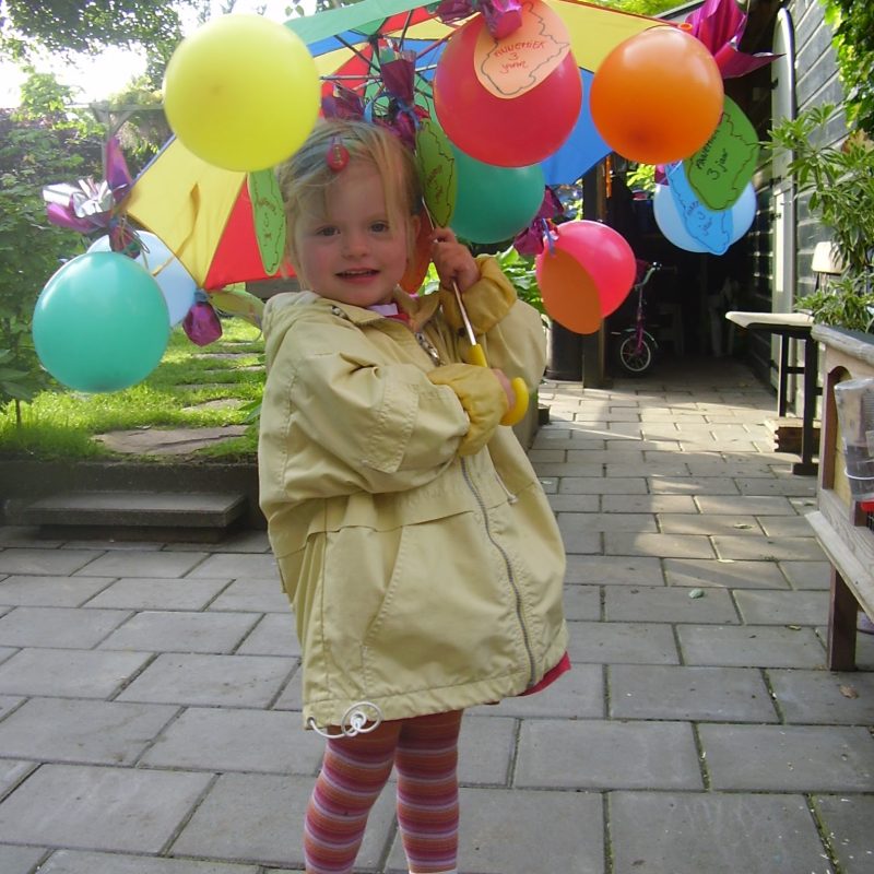 Feestelijke kinderfoto met kleurrijke paraplu – symbool voor creativiteit en verhalen bij Bij Mieks in Lochem